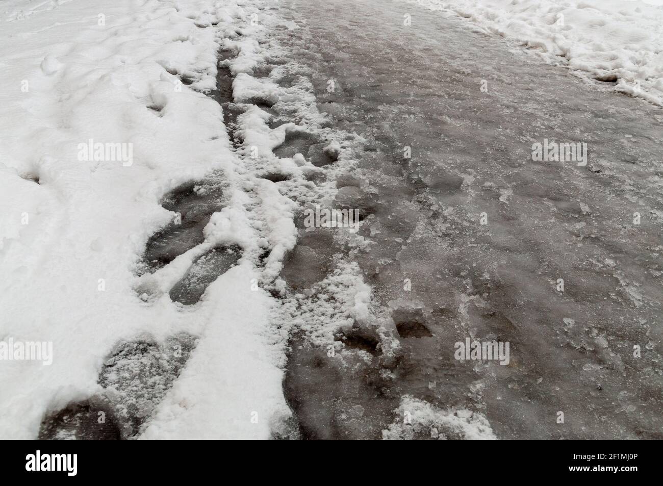 Fußabdrücke im Schneeslauch. Stockfoto