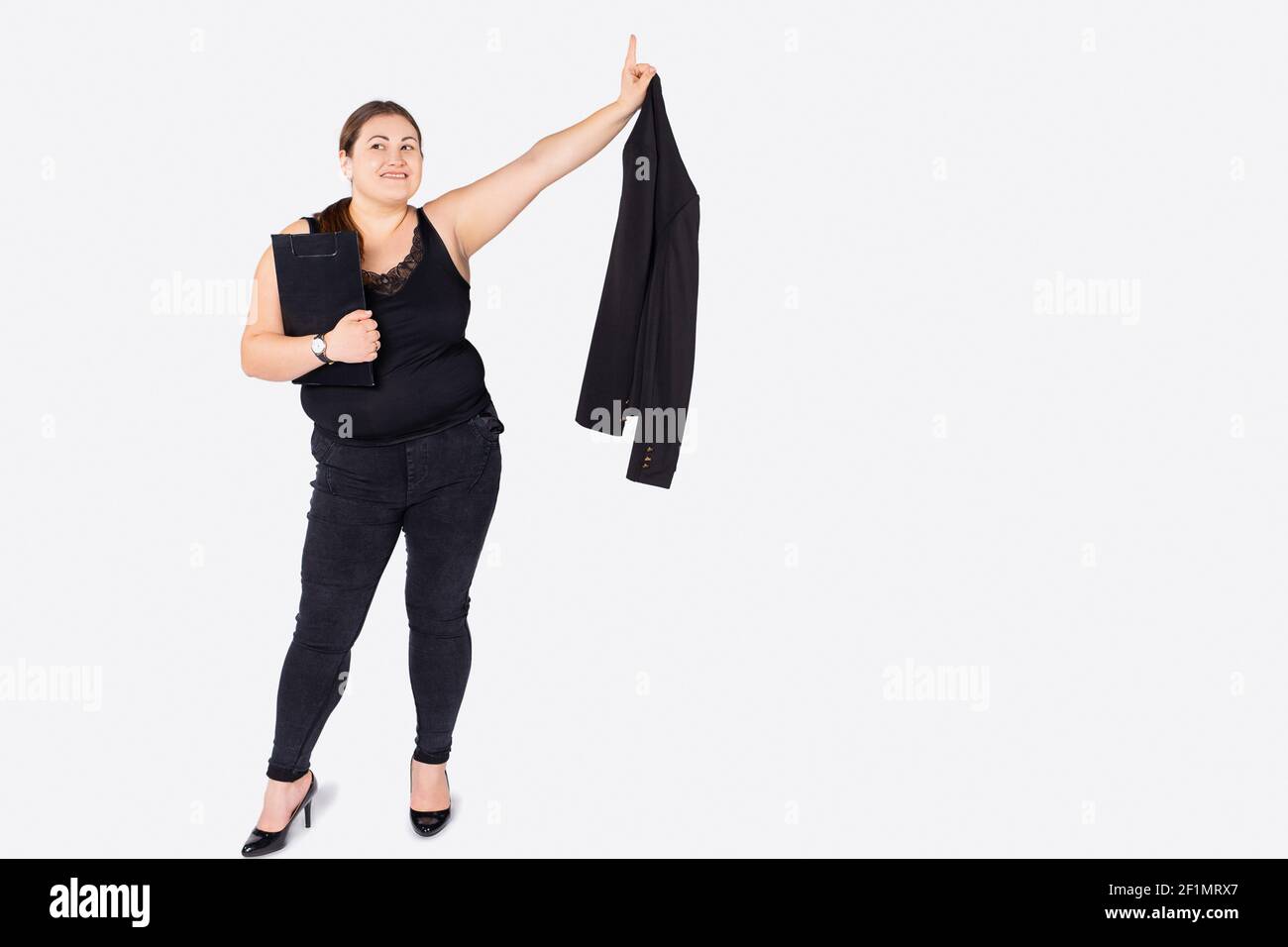 Ein Foto einer ausgewachsenen prallen Frau in Bürokleidung auf weißem Hintergrund zeigt Zeigefinger bis zur Seite leerer Raum für Ihre Werbung. Stockfoto