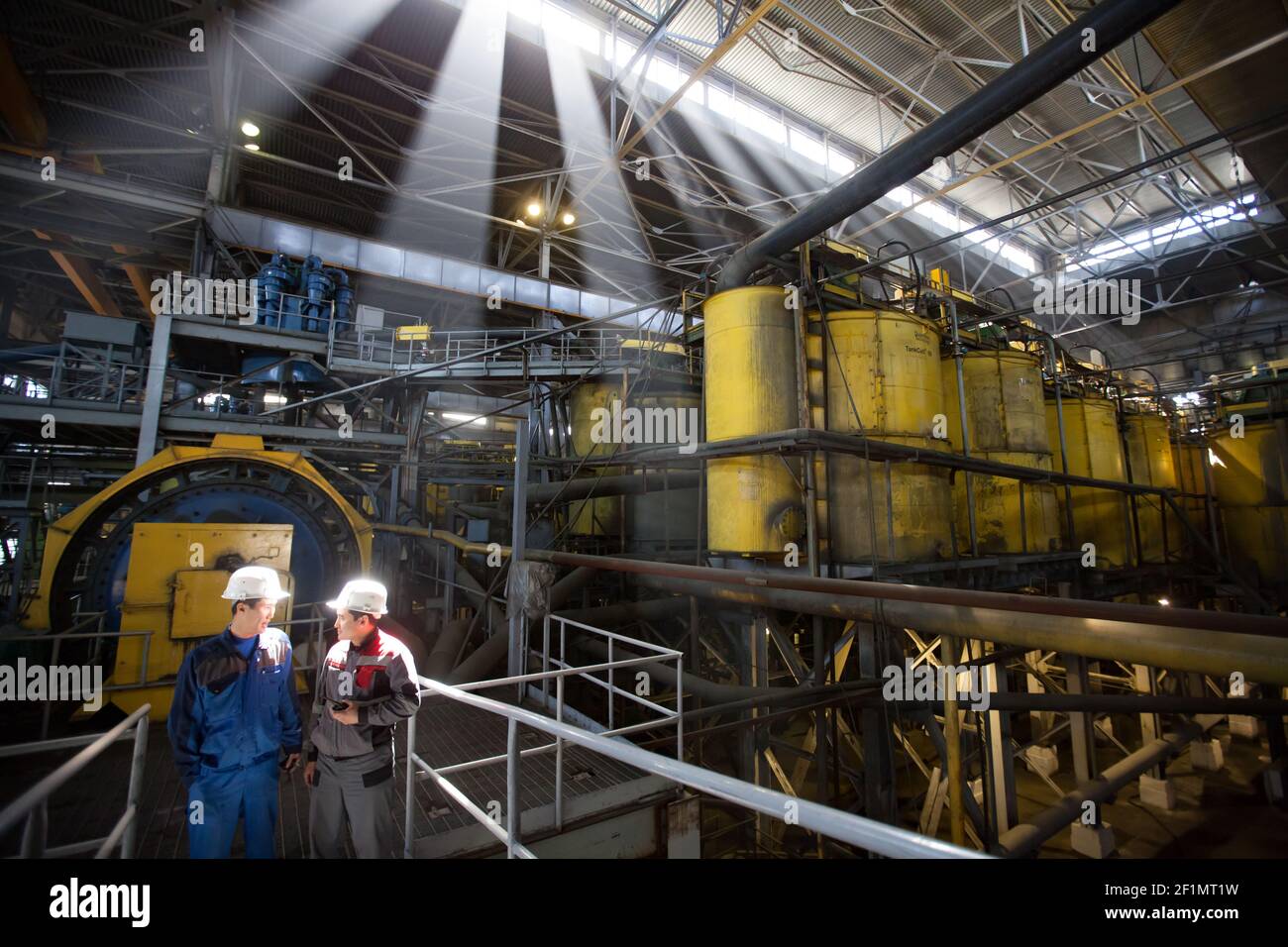 Khromtau/Kasachstan - Mai 06 2012: Werkstatt für Kupfererz-Konzentrationsanlagen. Ausstattung von Outokumpu Technology. Zwei asiatische Ingenieure diskutieren über Industrie Stockfoto