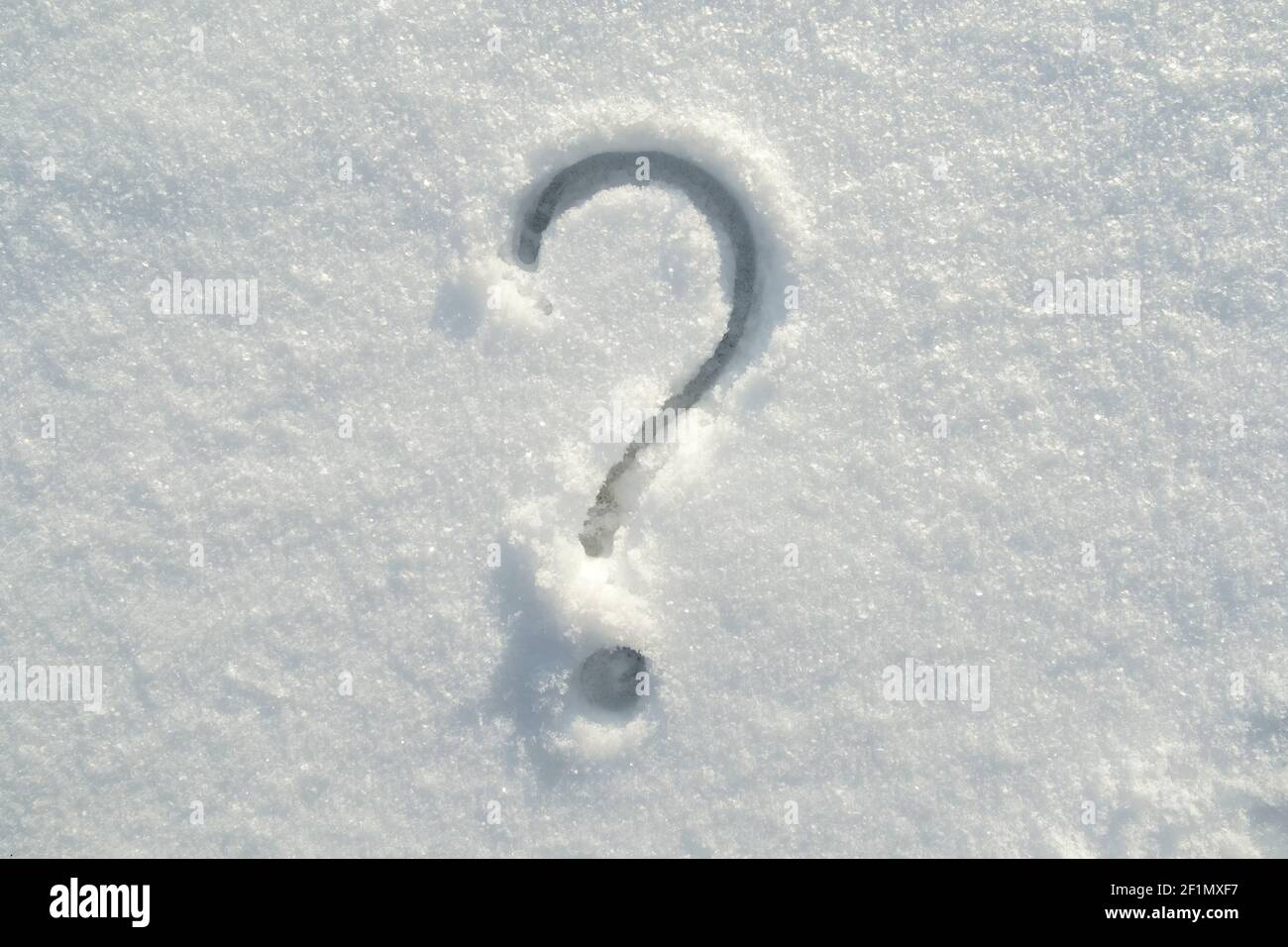 Satzzeichen Fragezeichen auf dem Neuschnee an einem sonnigen Wintertag gezeichnet. Stockfoto