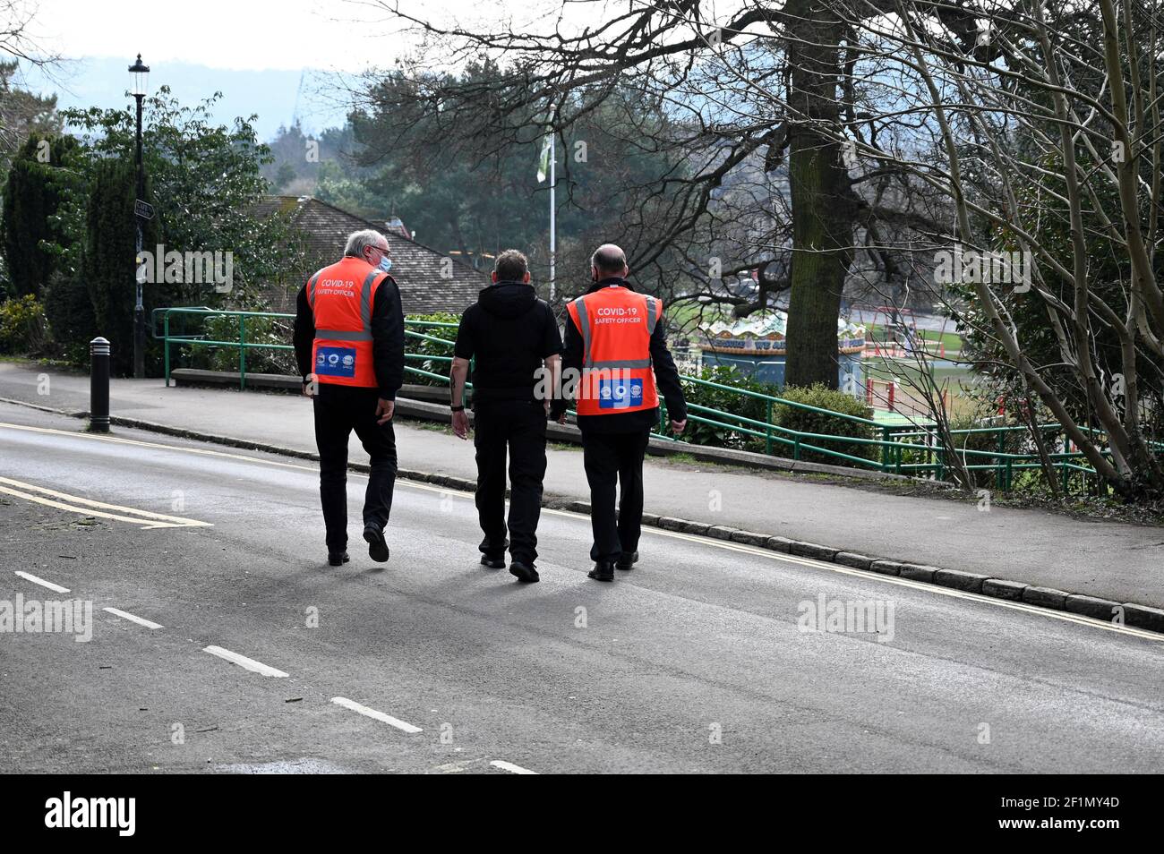 Bath, Großbritannien - 8. März 2021: Sicherheitsbeamte in leuchtend orangefarbenen Jacken patrouillieren im Victoria Park in Bath während der Pandemiesperre von Covid-19. Wichtiger Service Stockfoto