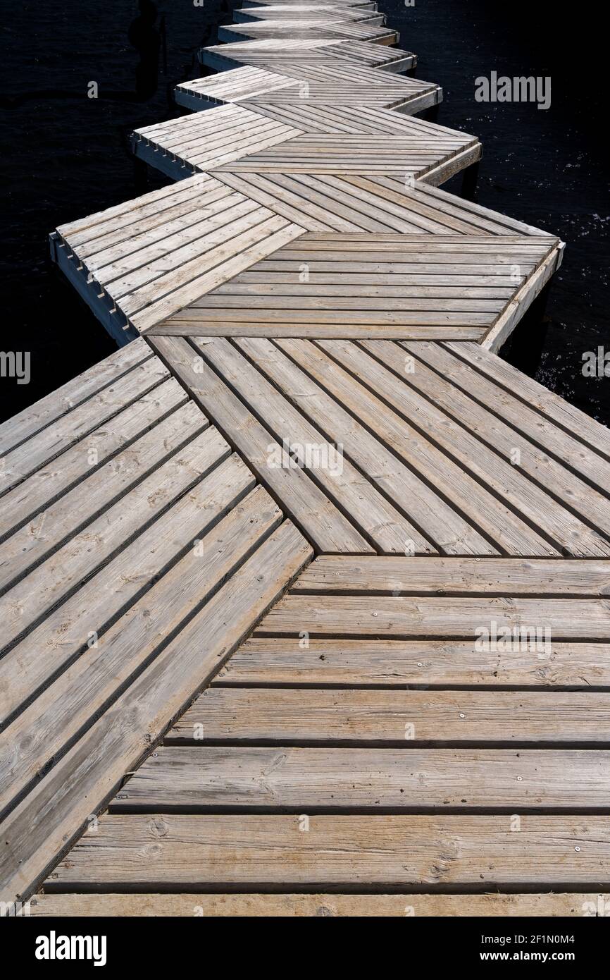 Eine Nahaufnahme aus einem tiefen Winkel abstrakte Ansicht eines Holzes Promenade und Pier, die in den Ozean führen Stockfoto