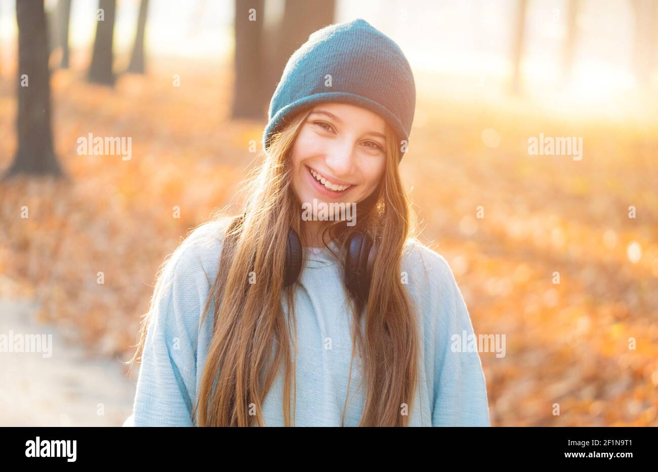 Glückliches Mädchen mit Kopfhörern im Herbst Park Stockfoto