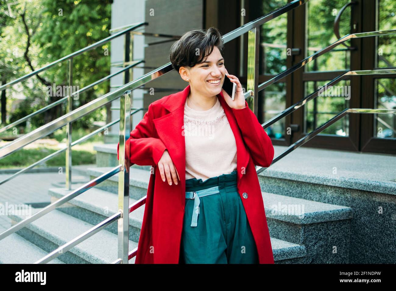 Young Business Professionals, gen z Frau arbeiten, erster Job, Praktikanten, Praktikum. Junge Brünette kurze Haare Geschäftsfrau mit sprechen Handy Stockfoto