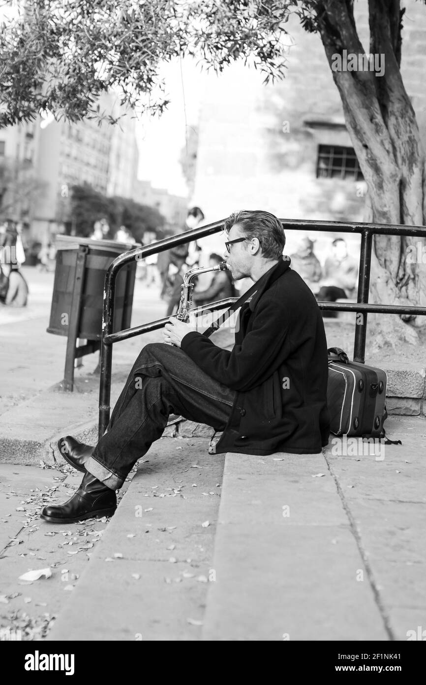 BARCELONA, SPANIEN - 13. Feb 2021: Barcelona, Spanien - 13,2021. Februar: Musiker spielt Saxophon auf der Treppe in der Straße in Barcelona Stockfoto