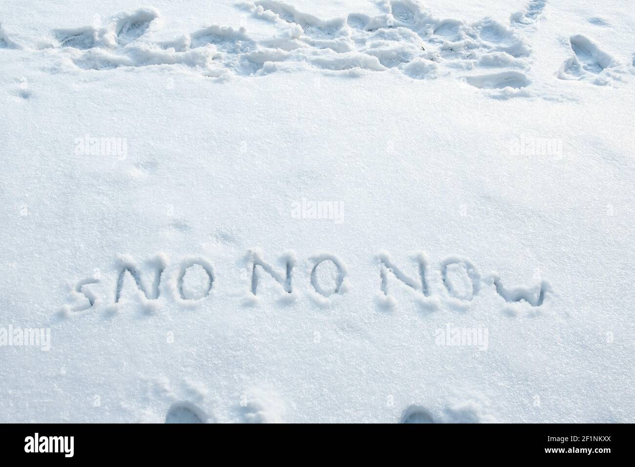 Wort von Schnee und dreimal in großen Buchstaben NICHT auf einer Schneebank geschrieben. Spring Anticipation Konzept. Speicherplatz kopieren. Kreative Idee. Stockfoto