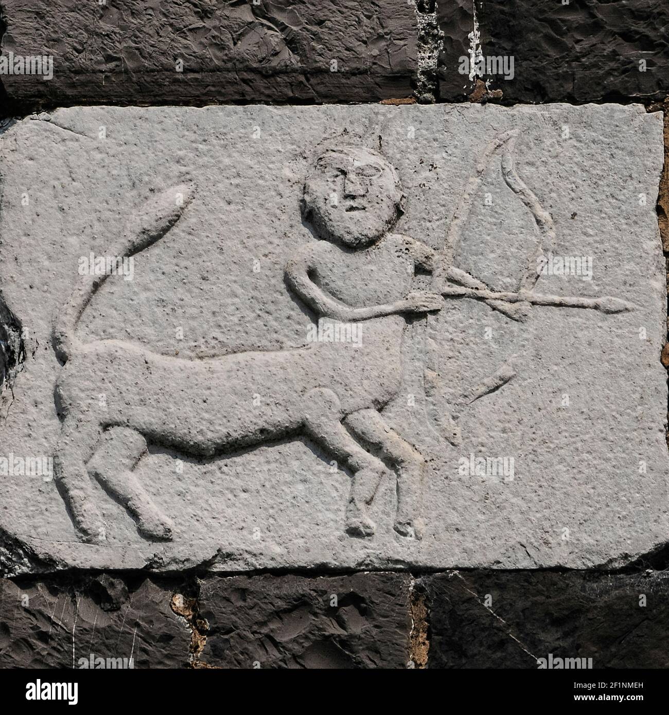 Schütze, Bogenkentaur der antiken Mythologie und neuntes Tierkreiszeichen. Frühmittelalterliches (5.. Bis 10.. Jahrhundert) Relief aus weißem Marmor, das vor der Kirche aus dem 12.. Jahrhundert, der romanischen Chiesa di Santa Maria del Tiglio in Gravedona, Lombardei, Italien, gemeißelt wurde. Die Schnitzerei ist deutlich vor der Kirche. Stockfoto