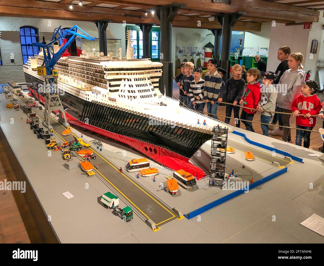 Hamburg, Deutschland - 11/3/2018. Das größte Modelleisenbahn-Diorama der Welt, Wunderland. Die Kinder sehen sich das Backstein-Kreuzfahrtschiff im Maritime Museum an Stockfoto