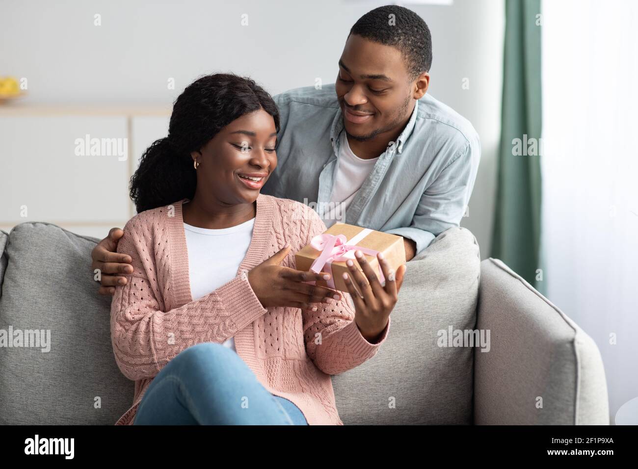 Geburtstag, Jubiläum, internationale Frauentag-Feier Konzept. Romantische schwarz Kerl geben Geschenk seine glücklich Freundin, afroamerikanisch jung f Stockfoto Geburtstag, Jubiläum, internationale Frauentag-Feier Konzept. Romantische schwarz Kerl geben Geschenk seine glücklich Freundin, afroamerikanisch jung f Stockfoto