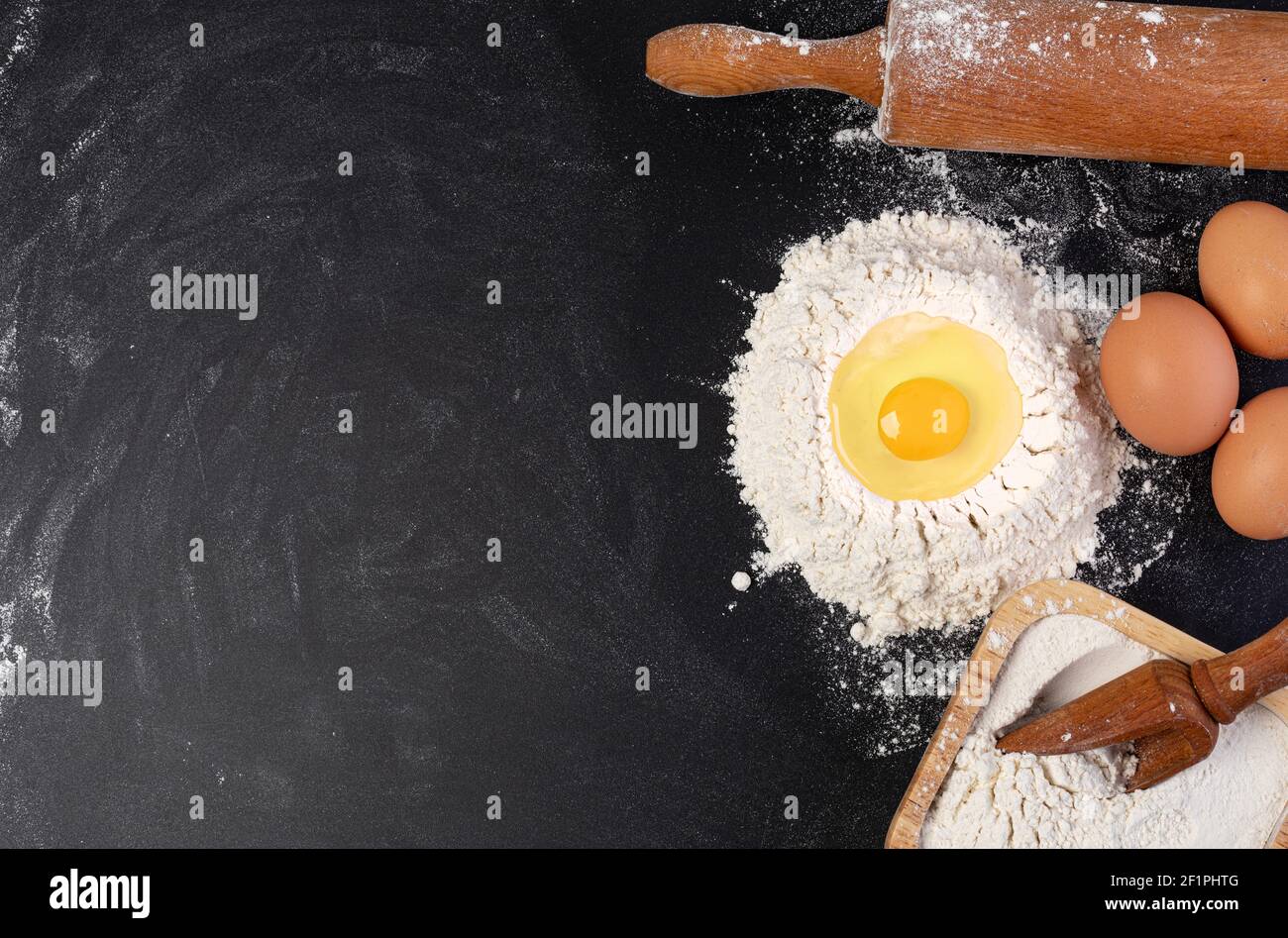 Rolling Pin und weißes Mehl auf einem dunklen Hintergrund Stockfoto