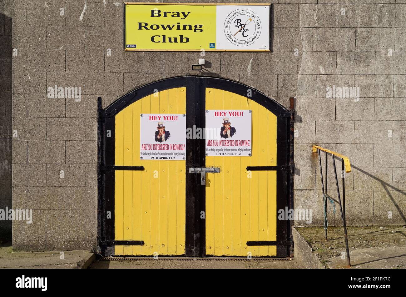 BRAY, IRLAND - 16. März 2020: Eingang zum Bray Rowing Club in Bray. Geschlossene gelbe Holztür mit Plakaten lädt zu einem Tag der offenen Tür in der Stockfoto