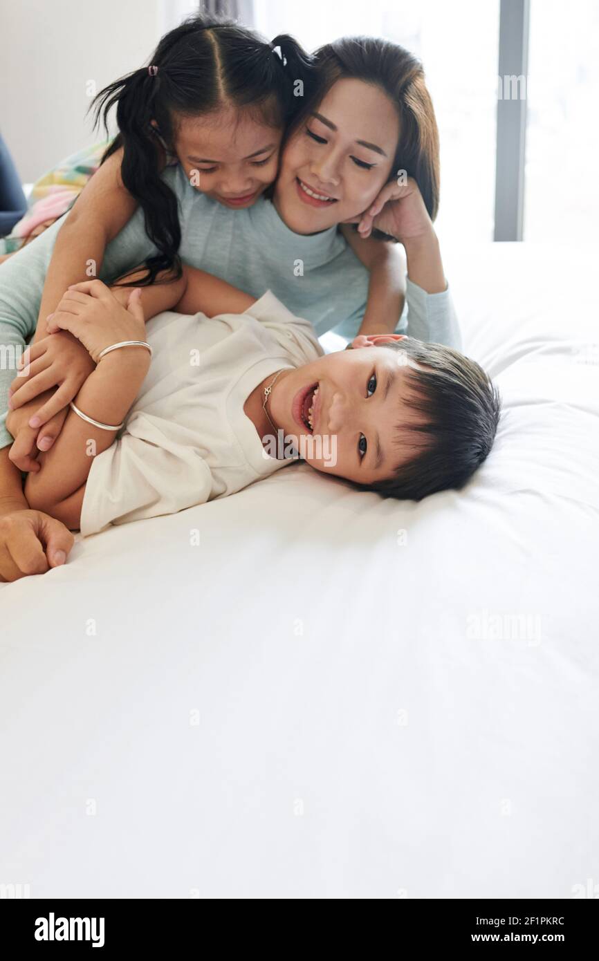 Glücklich wenig asiatisch junge genießen spielend mit Mutter und Schwester Und Blick auf die Kamera Stockfoto