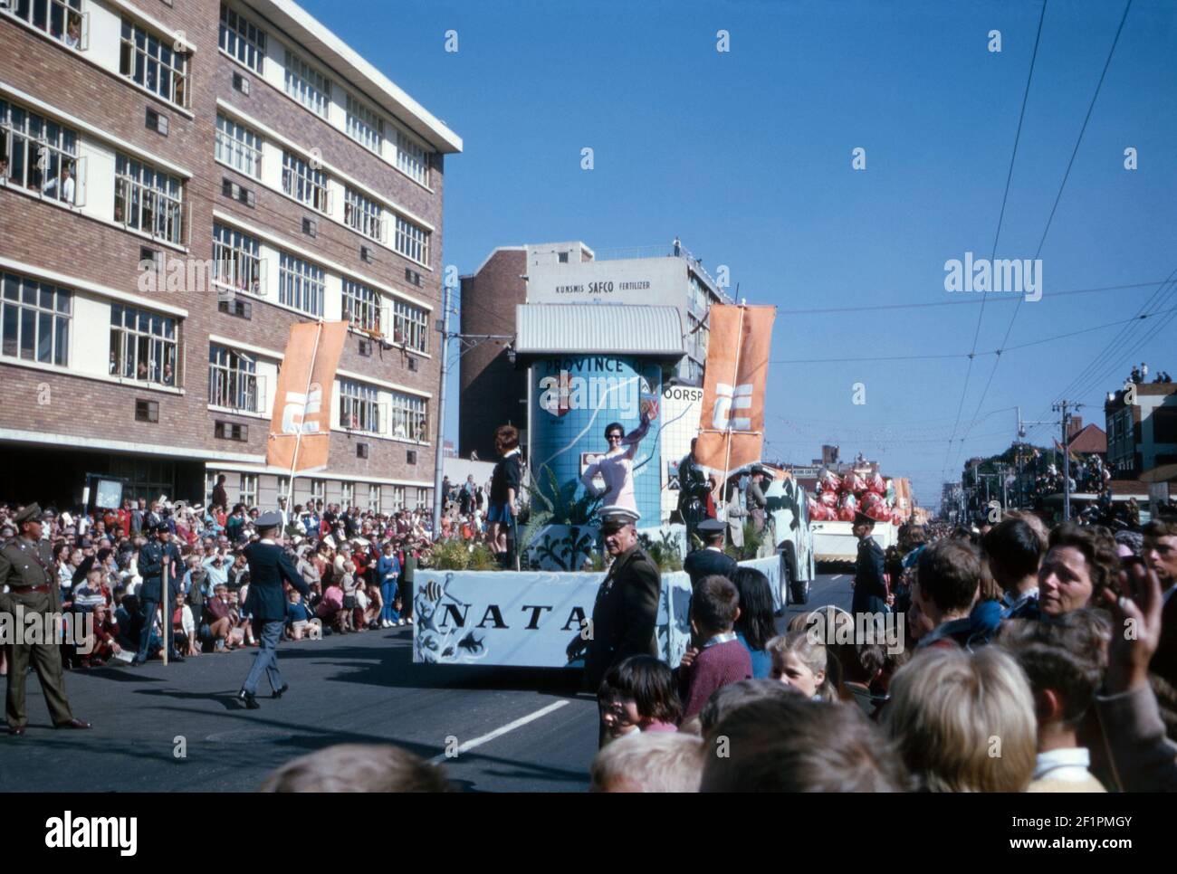 Parade-Festwagen zur Förderung der Provinz Natal, während der Apartheid-Ära, Durban, Südafrika, 1966. Der Festwagen wurde mit Fauna und Flora aus der Gegend geschmückt. Es ist sehr viel ein weißes Publikum Betrachten dieses Ereignis. Die Provinz Natal war von 1910 bis 1994 eine Provinz Südafrikas. Ländliche Gebiete, die von der schwarzafrikanischen Bevölkerung Natal (dem Bantustan von KwaZulu) bewohnt wurden, wurden 1981 teilweise autonom. Die erste nicht-rassische Wahl war 1994. In diesem Jahr wurde der KwaZulu-Bantustan in Natal reinkorporiert und die Provinz in KwaZulu-Natal umbenannte – ein Vintage-Foto aus dem Jahr 1960s. Stockfoto