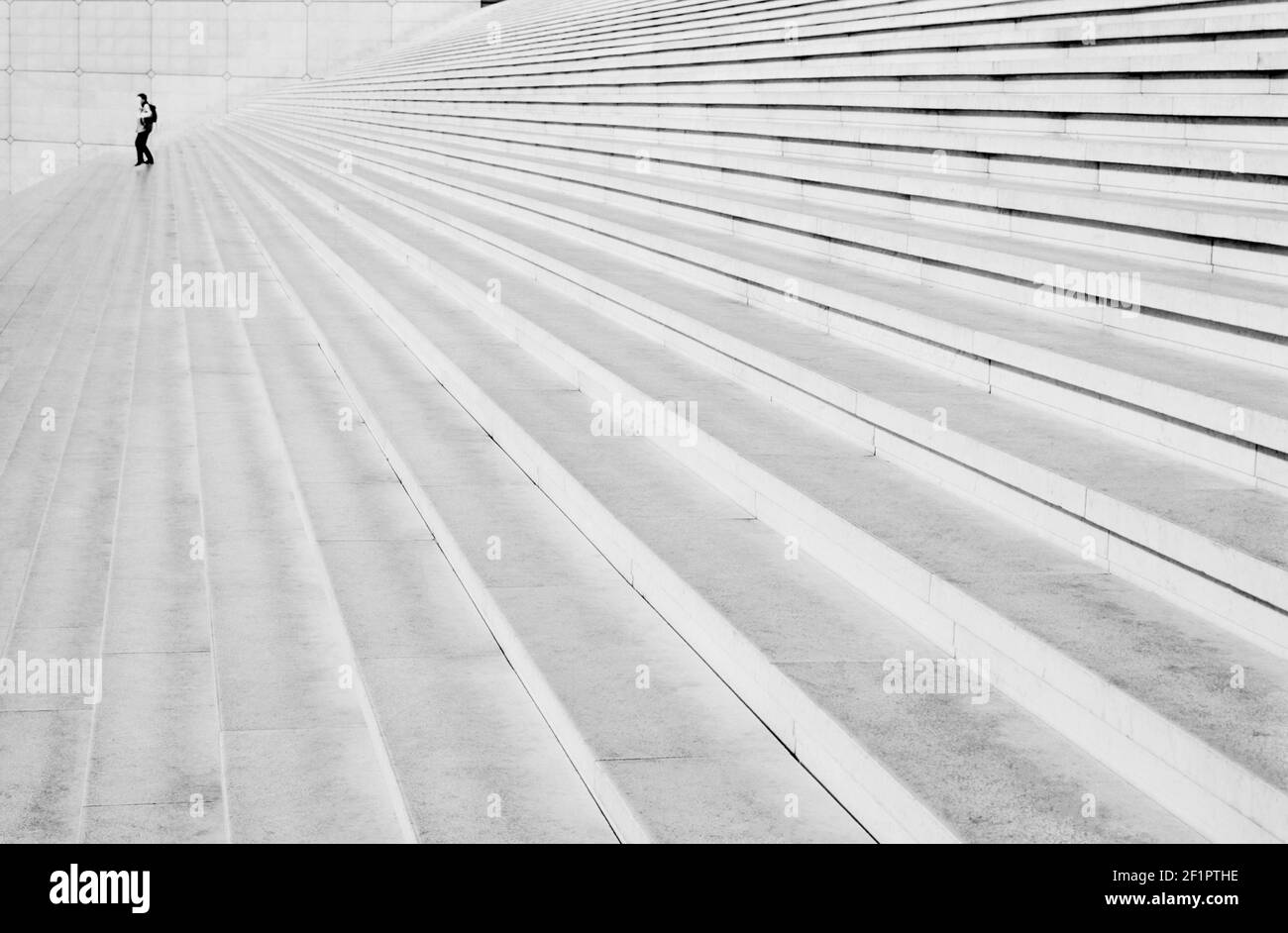 2002 - Paris La Defense - Lone Figure auf den Stufen der Grande Arche bei La Defense Paris Frankreich EU Europa. La Défense ist ein wichtiges Geschäftsviertel, das drei Kilometer westlich der Stadtgrenze von Paris liegt. Es ist Teil der Pariser Metropolregion in der Region Île-de-France.La Grande Arche de la Défense, "der große Bogen der Verteidigung", ursprünglich La Grande Arche de la Fraternité "Fraternity" genannt, ist ein Denkmal und Gebäude im Geschäftsviertel von La Défense. Es ist in der Regel als die Arche de la Défense oder einfach als La Grande Arche bekannt Stockfoto