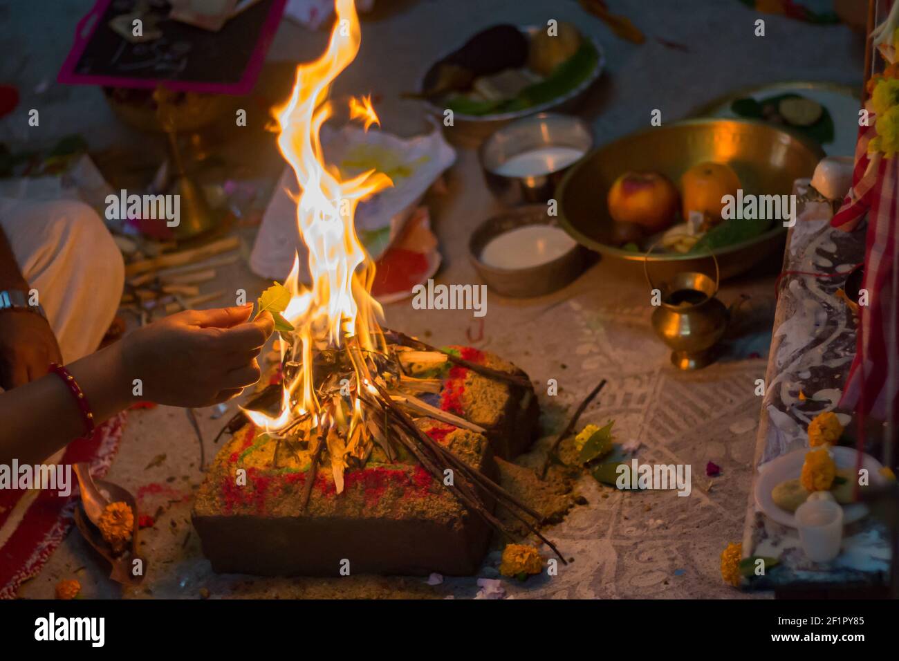 Heiliges Feuer brennt während hinduistischer religiöser Rituale in der lokalen bengalischen Kultur. Alle wesentlichen Elemente der Puja sind im Hintergrund. Typisch indisch Stockfoto