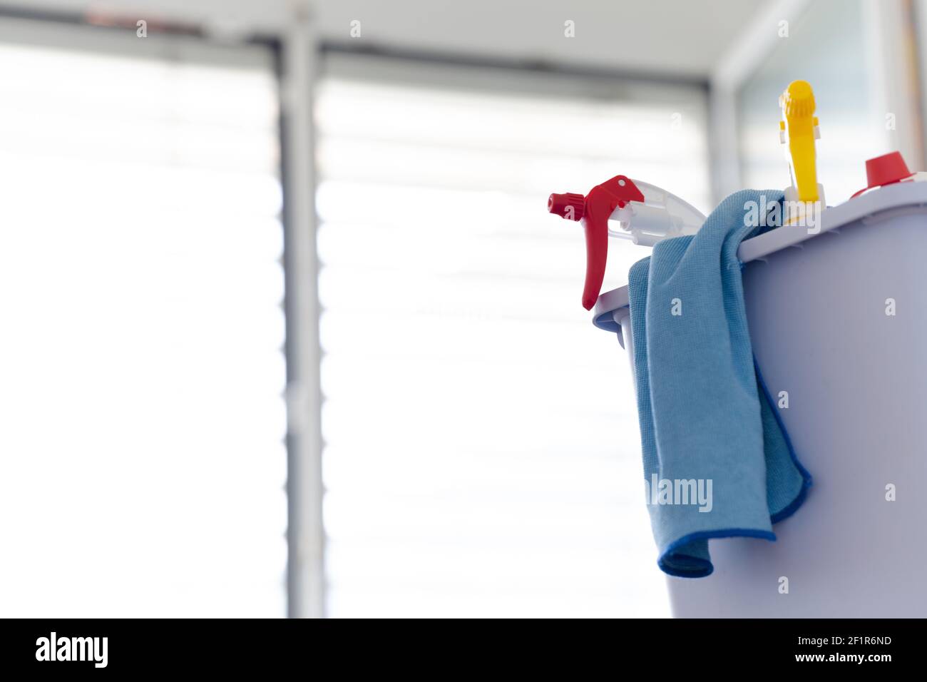 Nahaufnahme der Sprühflaschen in einem Eimer mit einem Mikrofasertuch für die professionelle Fensterreinigung Stockfoto
