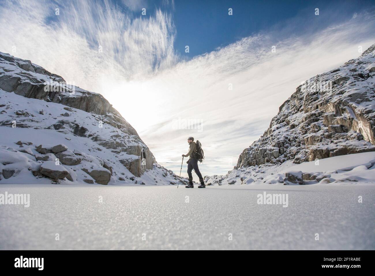 Silhouettenansicht von Rucksacktouristen, die zwischen zwei Bergen wandern. Stockfoto