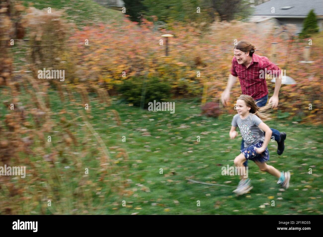 Ein Mann und ein Mädchen Rennen im Hinterhof in Der Fall Stockfoto