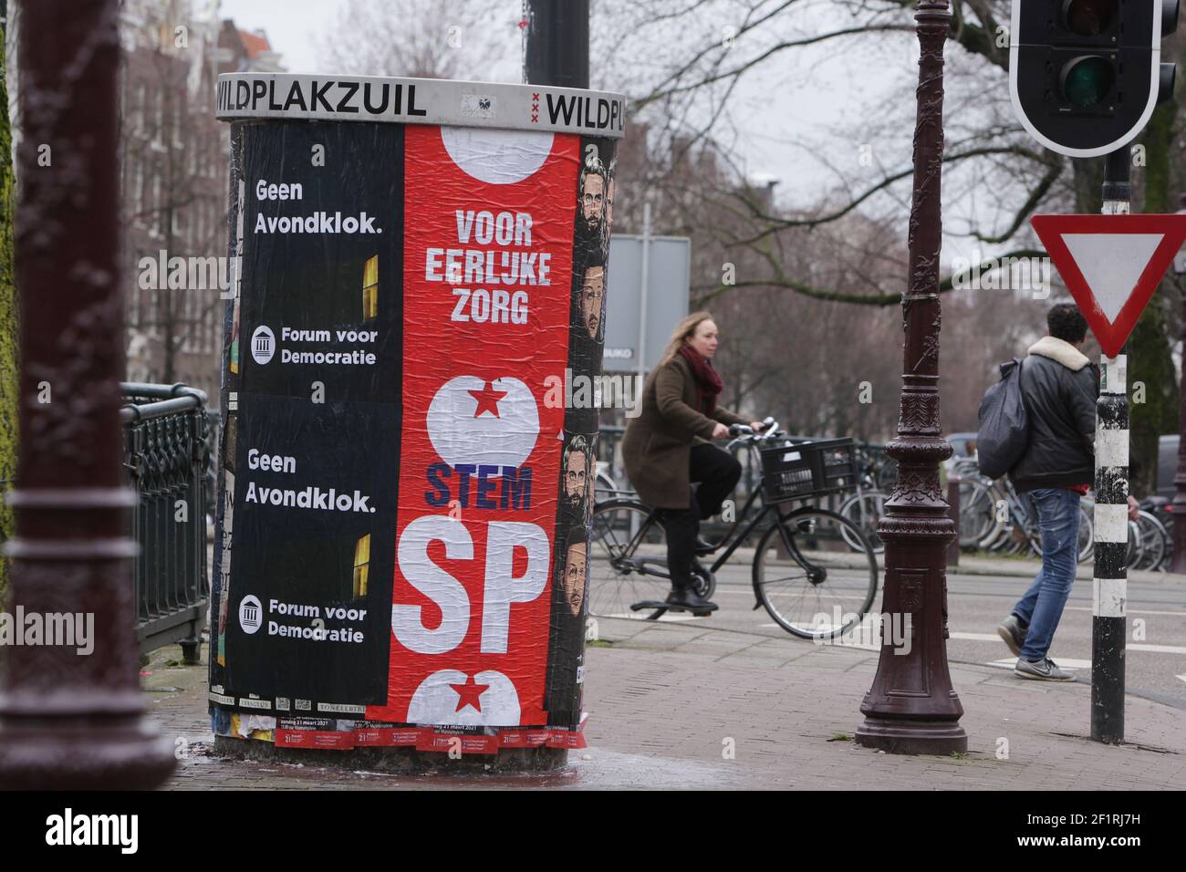 Mitglieder der öffentlichen Vergangenheit durch eine Wahlkampagne Plakat mit niederländischen politischen Parteien fast menschenleer Straße inmitten der Coronavirus-Pandemie am 9. März 2021 in Amsterdam, Niederlande. Die Niederlande gehen an die Wahlen, um eine neue Regierung am 17. März zu wählen. (Foto von Paulo Amorim/Sipa USA) Stockfoto