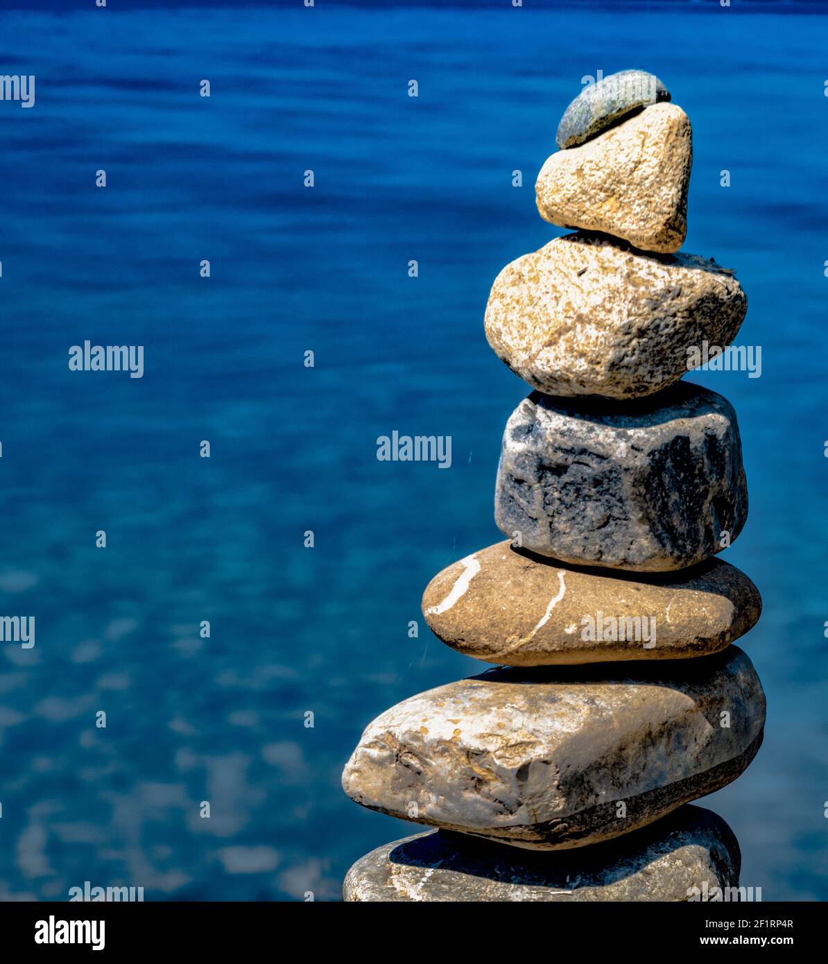 Meditative Steinkairn und blauer Wasserhintergrund mit Kopierraum Stockfoto