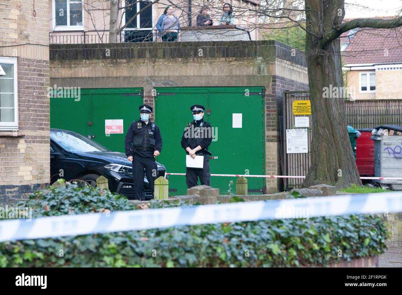 London, Großbritannien, 9. März 2021: Die Polizei durchsucht einen Wohnblock, Poynders Court, auf der A205 Poynders Road, und das Met bestätigte, dass es im Zusammenhang mit Sarah Everards Verschwinden steht. Die 33-jährige Frau wird seit dem 3. März vermisst. Die Polizei hat das South Circular abgesperrt und Polizisten in weißen Forensik-Anzügen warten in Transportern am Rand der Polizeikordel. Eine Menge von Einheimischen und Reportern hat sich versammelt und einige Leute beobachten die Ereignisse von ihren Balkonen aus. Anna Watson/Alamy Live News Stockfoto