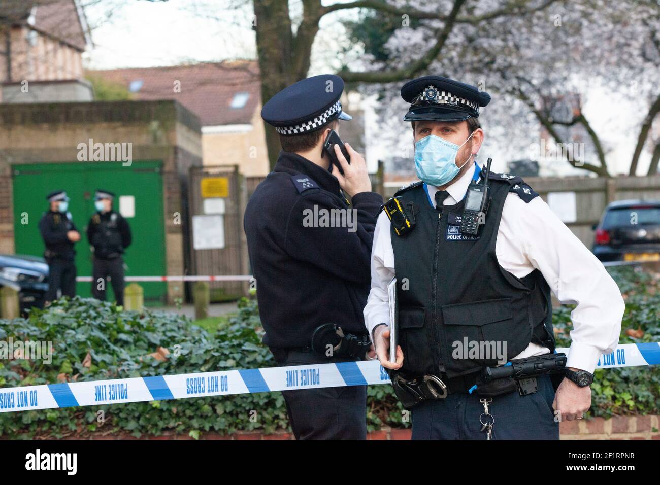 London, Großbritannien, 9. März 2021: Die Polizei durchsucht einen Wohnblock, Poynders Court, auf der A205 Poynders Road, und das Met bestätigte, dass es im Zusammenhang mit Sarah Everards Verschwinden steht. Die 33-jährige Frau wird seit dem 3. März vermisst. Die Polizei hat das South Circular abgesperrt und Polizisten in weißen Forensik-Anzügen warten in Transportern am Rand der Polizeikordel. Eine Menge von Einheimischen und Reportern hat sich versammelt und einige Leute beobachten die Ereignisse von ihren Balkonen aus. Anna Watson/Alamy Live News Stockfoto