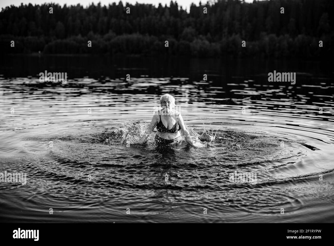 Alte Frau im Sommer im Fluss. Schwarzweiß-Foto. Stockfoto
