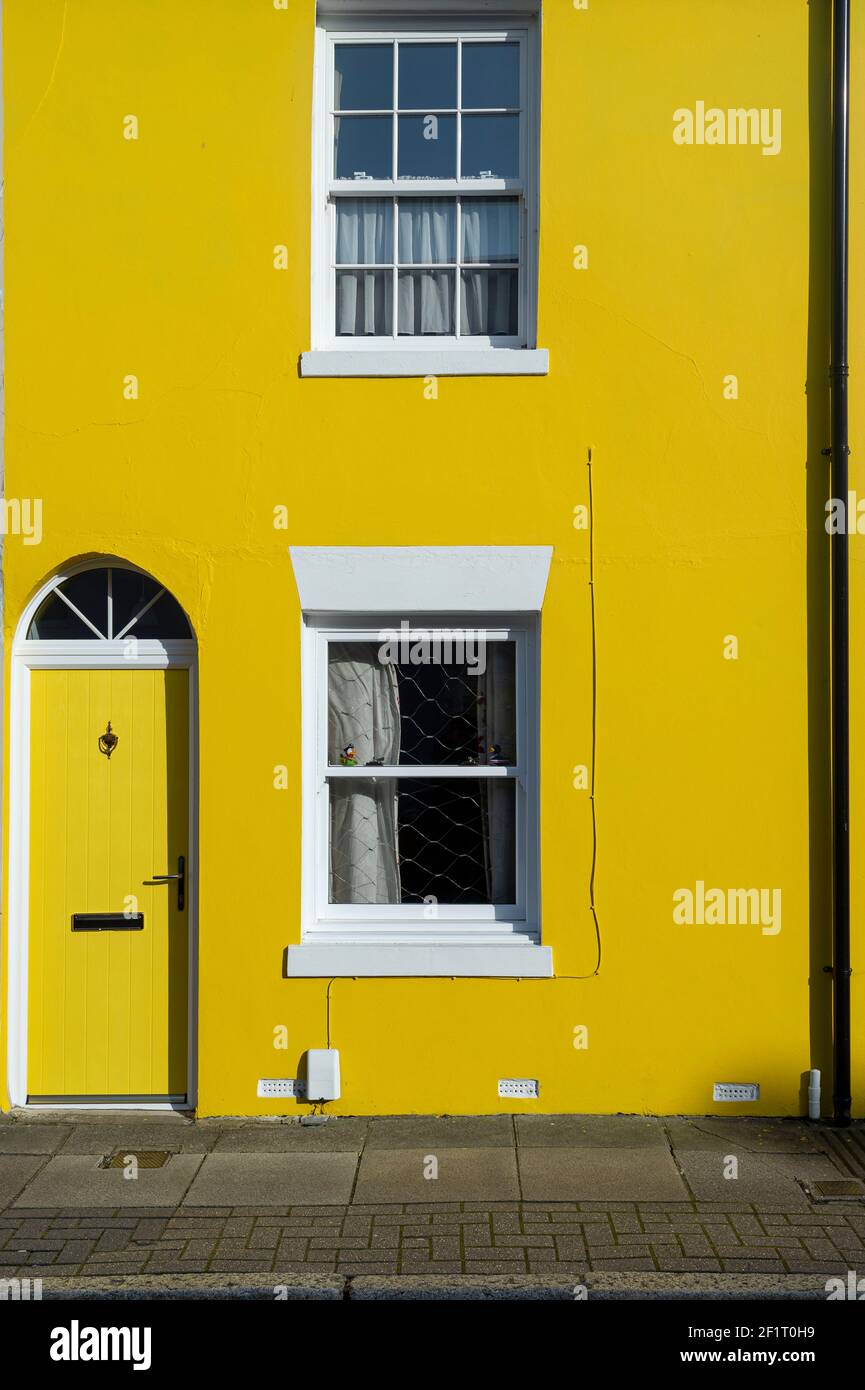 Haus gemalt hellgelb, Reihenhaus in einer Stadtstraße. Stockfoto