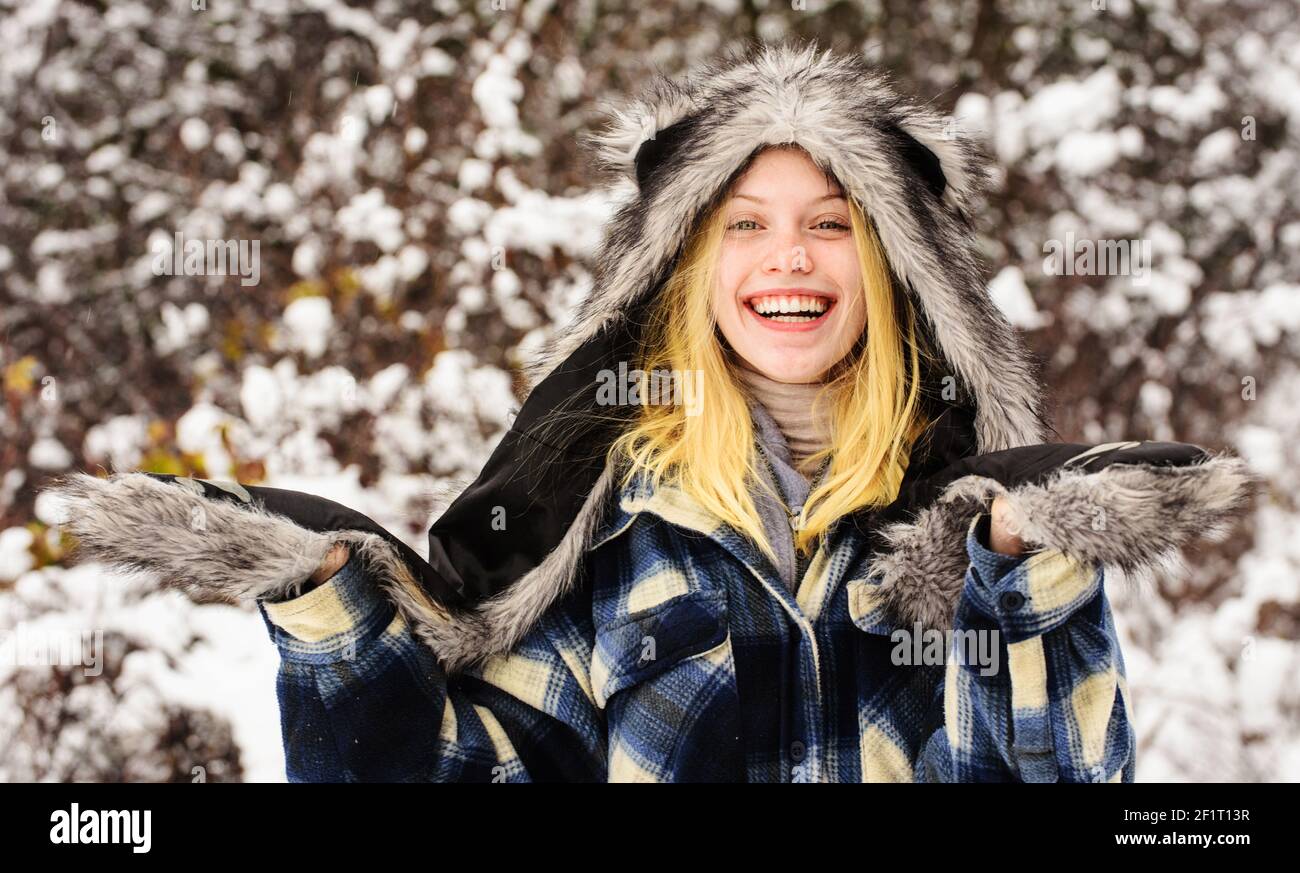 Mode Mädchen im Winter. Schöne Frau in warmer Kleidung im Winter Park. Fröhliches Weibchen in warmem Mantel, Pelzhut und Fäustlingen. Stockfoto
