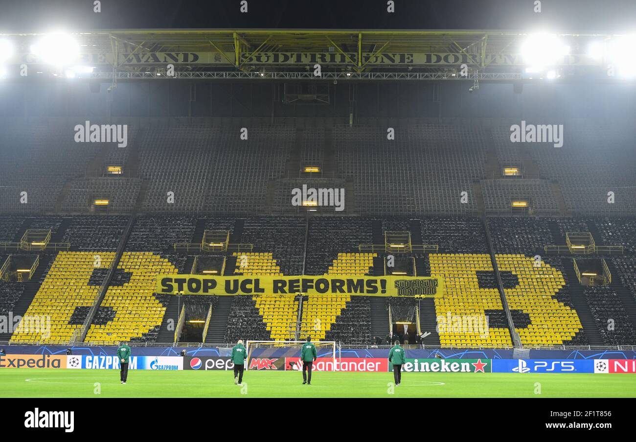 09. März 2021, Nordrhein-Westfalen, Dortmund: Fußball: Champions League, Borussia Dortmund - FC Sevilla, K.O.-Runde, Runde 16, 2. Etappe im Signal Iduna Park. UEFA-Vertreter gehen über das Spielfeld, während ein Banner mit der Aufschrift "Stop UCL reforms" in einem Stand vor dem Spiel zu sehen ist. WICHTIGER HINWEIS: Gemäß den Bestimmungen der DFL Deutsche Fußball Liga und/oder des DFB Deutscher Fußball-Bund ist es untersagt, im Stadion und/oder des Spiels aufgenommene Fotos in Form von Sequenzbildern und/oder videoähnlichen Fotoserien zu verwenden oder zu verwenden. Foto: Martin Meissner/AP-Poo Stockfoto