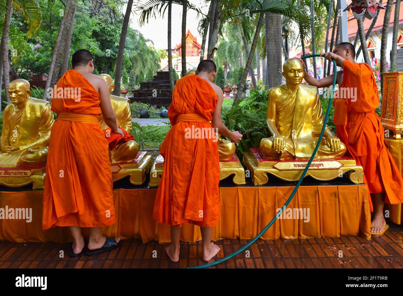 Buddhistische Mönche waschen religiöse Statuen im buddhistischen Tempel Wat Phra Singh, Chiang Mai, Thailand Stockfoto