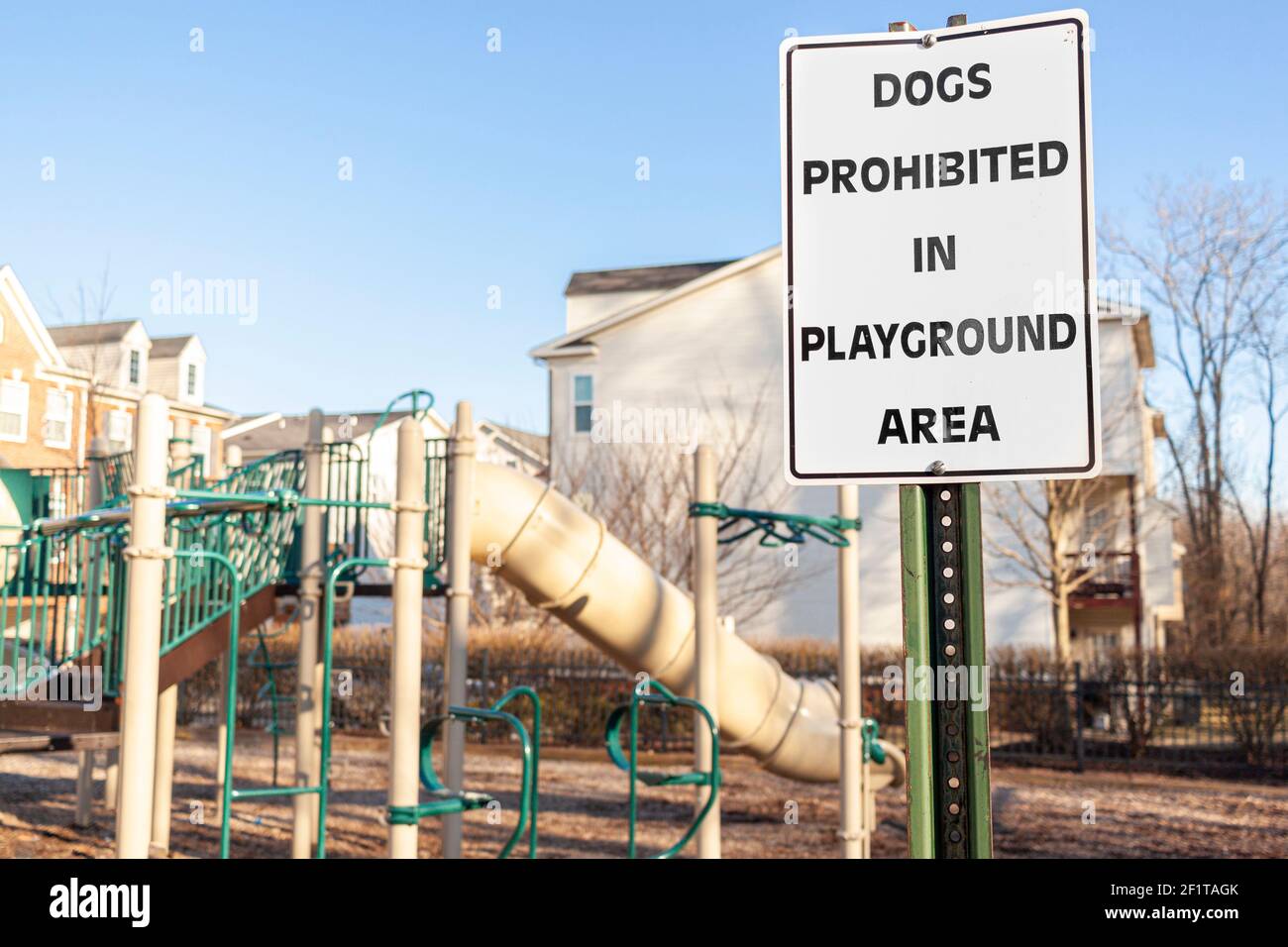 Hunde verboten im Spielplatz-Bereich Zeichen vor den Zäunen auf einem eingezäunten Spielplatz eines Wohnvorstadtviertels. Haustiere können Disturban verursachen Stockfoto