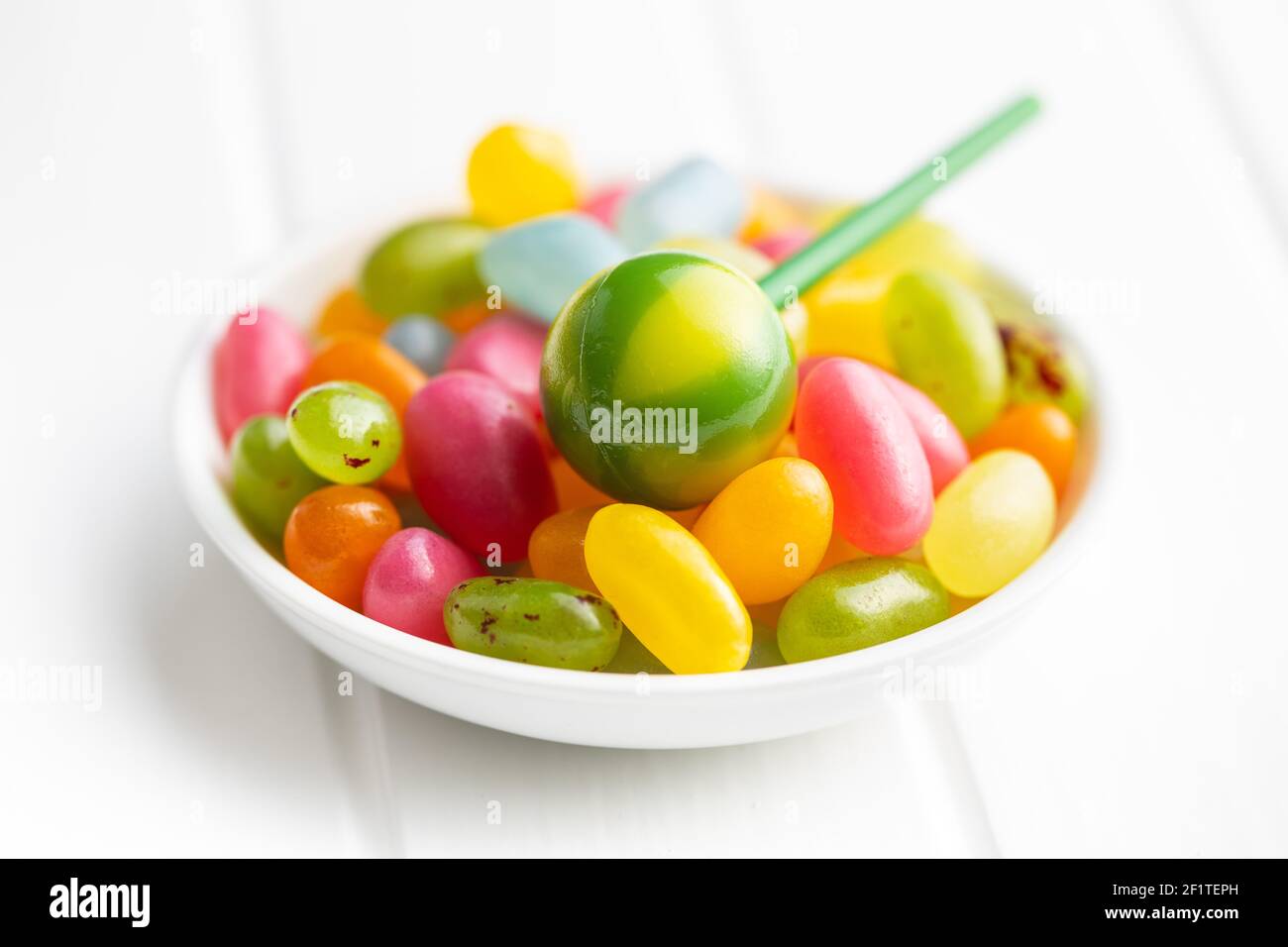 Süße, fruchtige Lutscher und Jelly Beans auf weißem Tisch. Stockfoto