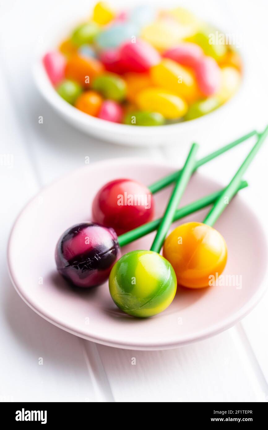 Süße, fruchtige Lutscher und Jelly Beans auf weißem Tisch. Stockfoto