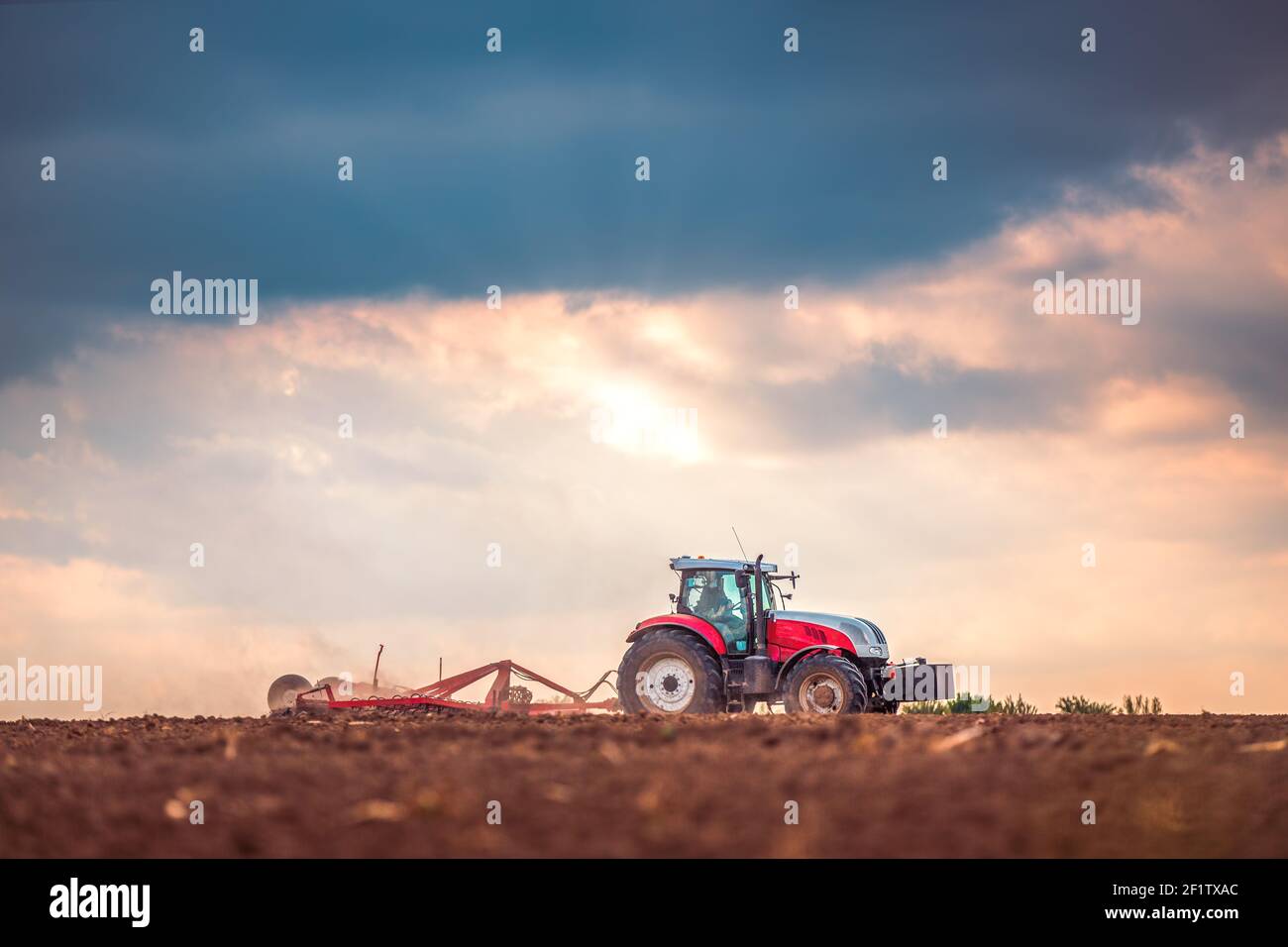 Landwirt in Vorbereitung der Flächen mit Saatbeet Grubber Traktor Stockfoto