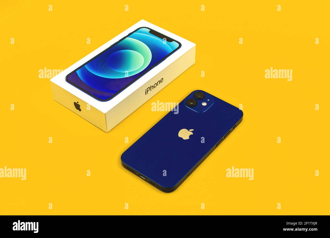 Charkow, Ukraine - 8. März 2021: Apple iPhone 12 mini mit Retail-Box, flach liegend, gelbes Hintergrundfoto Stockfoto
