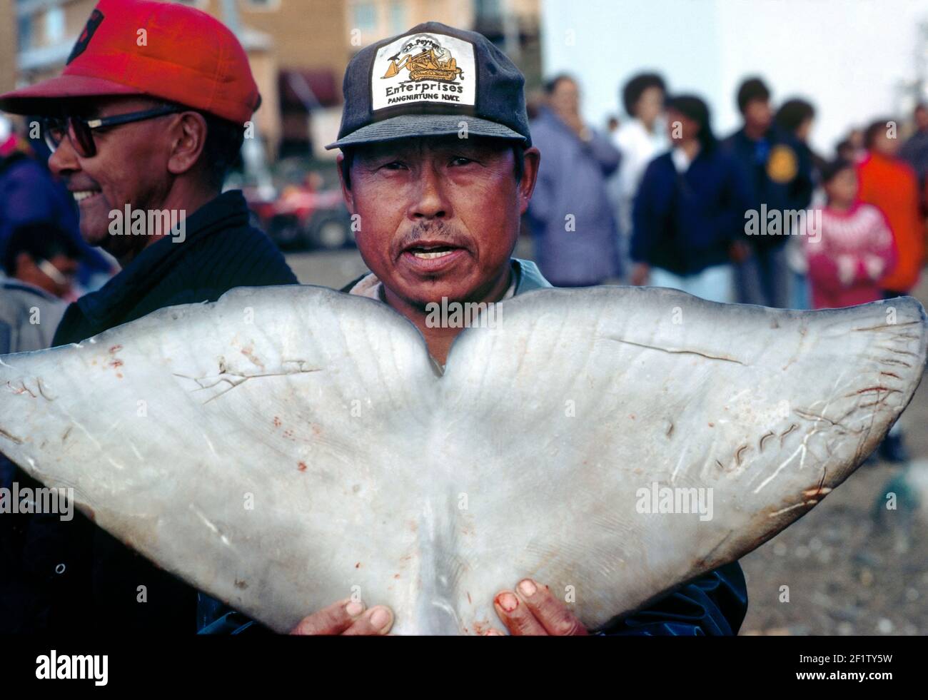 Inuit Fischer im kleinen arktischen Dorf Pangnirtung entladen frisch gefangenes Beluga Whale Fleisch für die Gemeinschaft; Baffin Island, Nunavut, Kanada Stockfoto