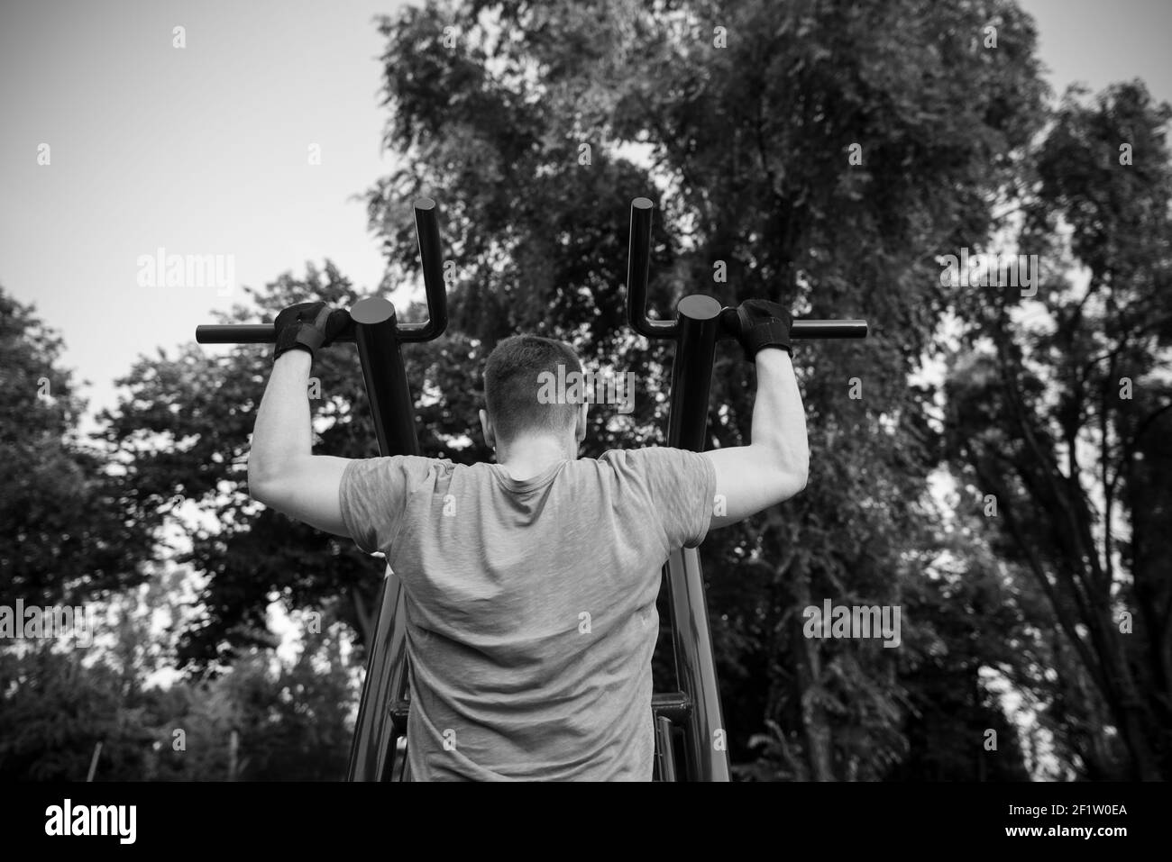 Guy Training im Fitnessbereich im Freien auf Übung Ausrüstung Stockfoto