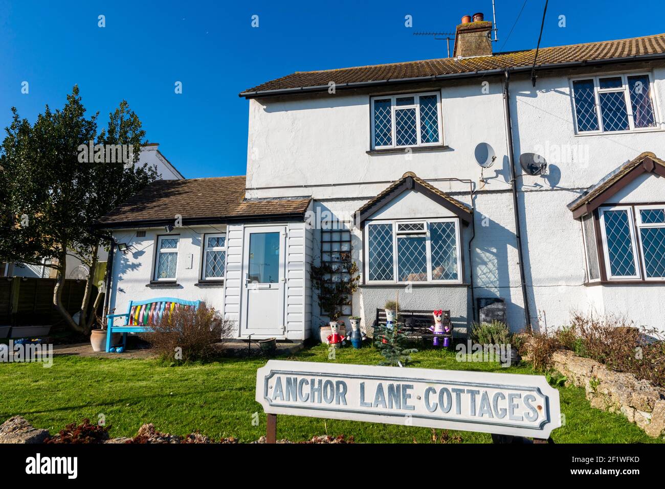 Anchor Lane Cottages in Canewdon, Essex, Großbritannien. Malerisches Anwesen mit farbenfrohen Blumentopf-Figuren Stockfoto