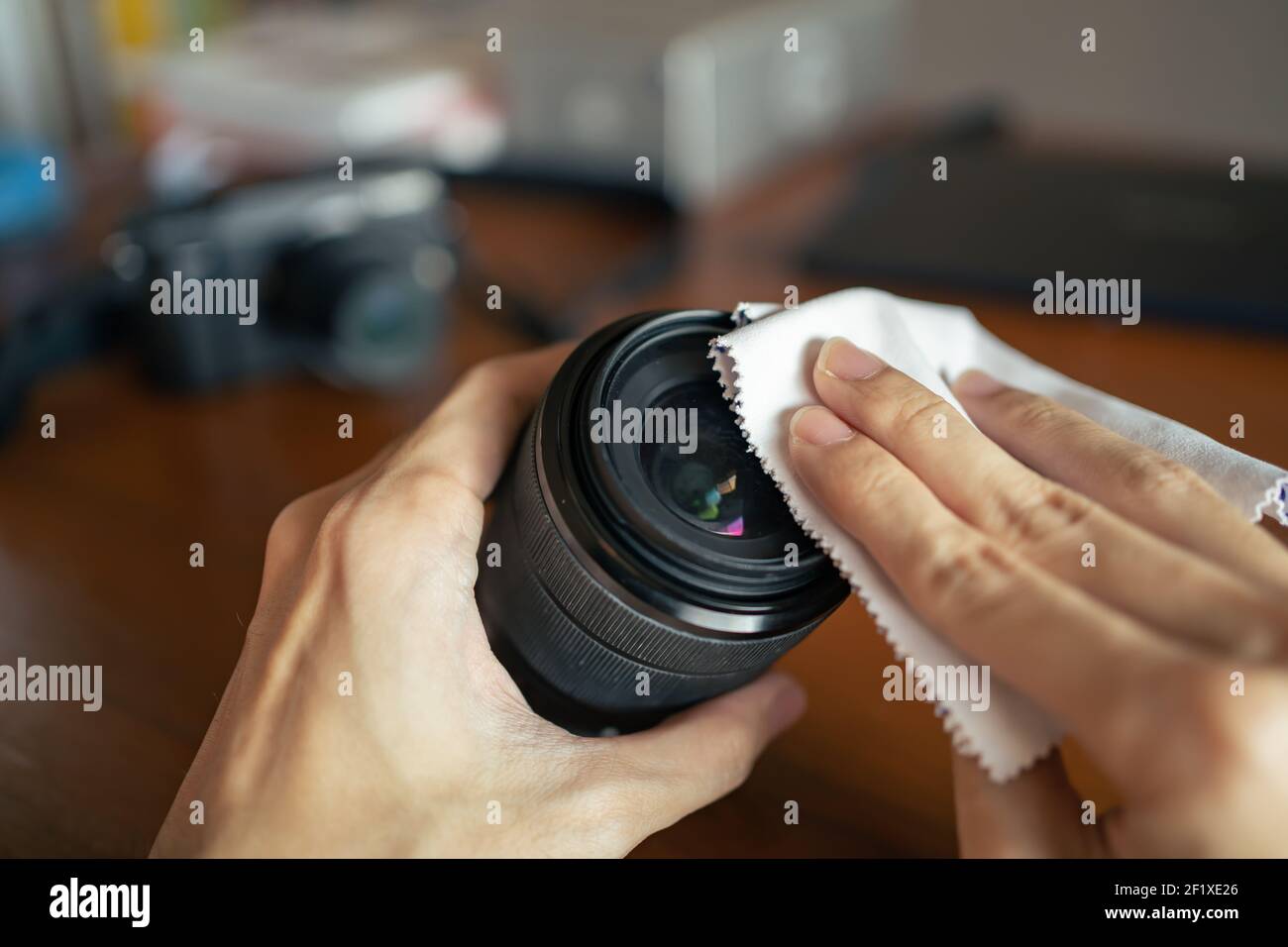 Kameralinse mit Mikrofasertuch abwischen Stockfoto