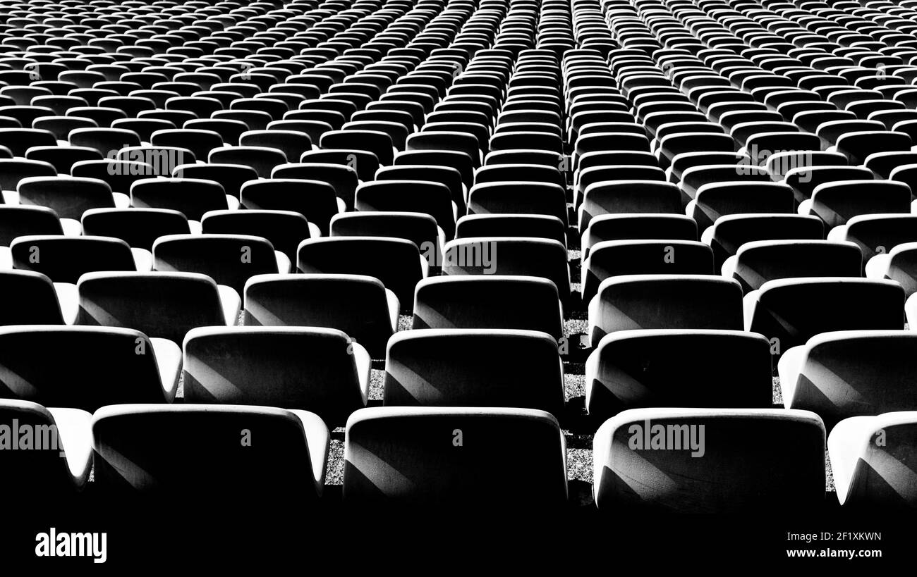 Schwarz-weiße Ansicht von endlosen Reihen von leeren Stühlen In einem Stadion Stockfoto