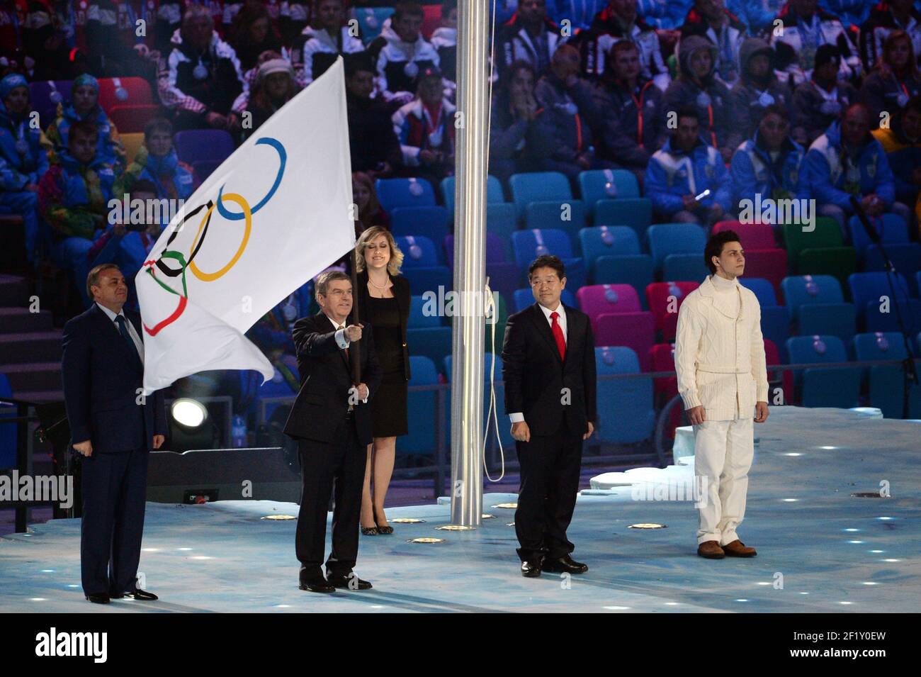Der IOC-Präsident Thomas Bach übergibt dem Bürgermeister von PyeongChang, dem Gastgeber der Olympischen Winterspiele 2018, während der Abschlussfeier der XXII. Olympischen Winterspiele Sotchi 2014 im Olympiastadion Fisht am 23. Februar 2014 in Sotschi, Russland, die olympische Flagge. Fotopool KMSP / DPPI Stockfoto
