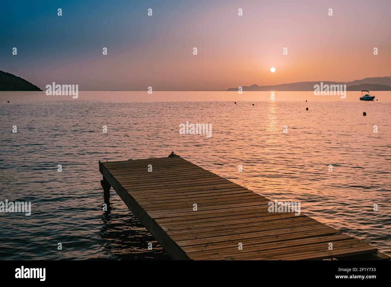 Sonnenaufgang, Holzsteg am Strand bei Sonnenaufgang mit goldenem Himmel. Urlaubs- und Reisekonzept. Kreta Griechenland Stockfoto