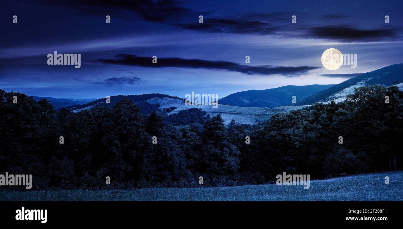 Sommerlandschaft der karpaten in der Nacht. Schöne Landschaft im Vollmondlicht. Buchenwald und grasbewachsenen Almwiesen auf den Hügeln. Wolken o Stockfoto