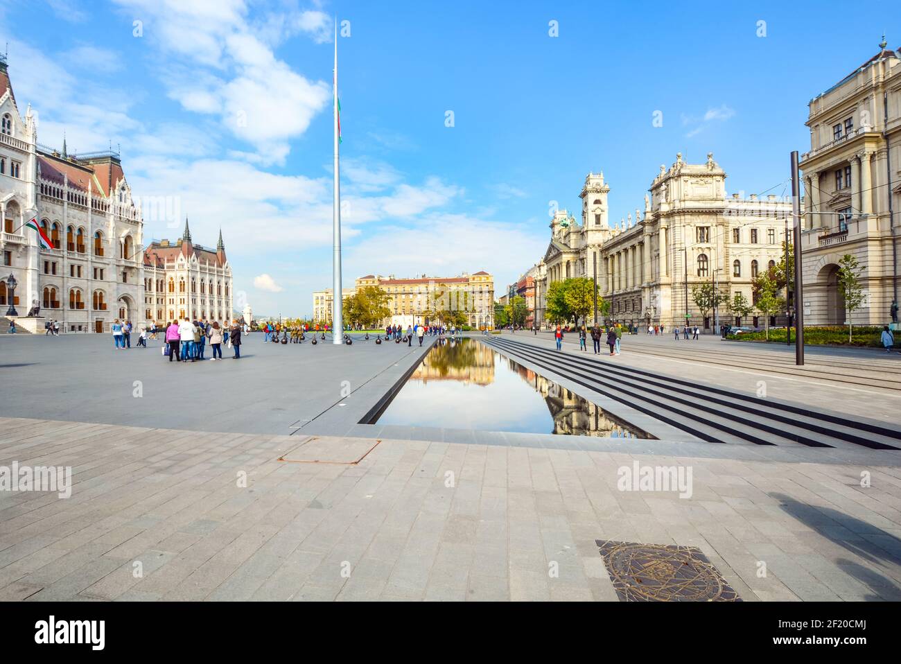 Parliament Square oder Kossuth Lajos Ter in Budapest, Ungarn mit Touristen, das Parlamentsgebäude und einen reflektierenden Pool an einem sonnigen Tag Stockfoto