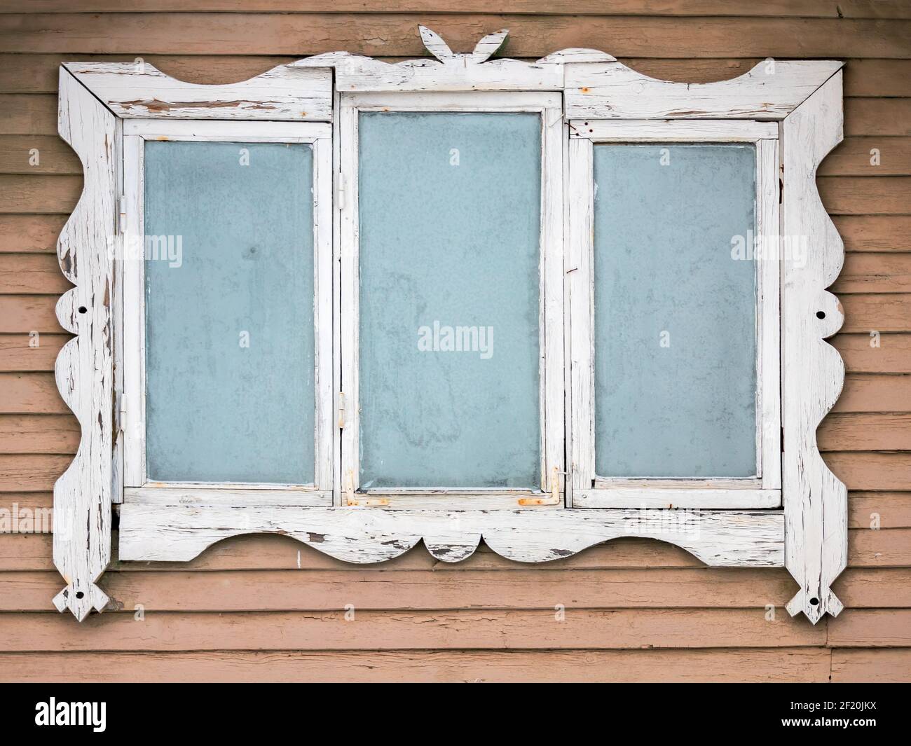 Gefrorenes Fenster in weißem dekorativen Rahmen, alte ländliche Holzhaus Wandfragment, Hintergrundtextur Stockfoto