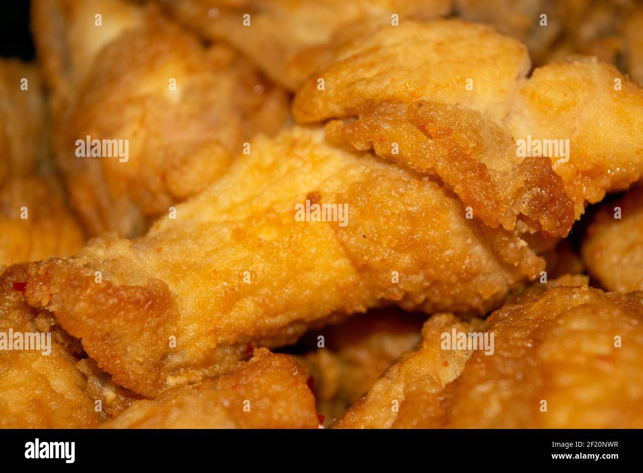 Kleine Stücke Hühnerfleisch mit Gewürzen in Paniermehl gebraten. Nahaufnahme mit selektivem Fokus. Stockfoto