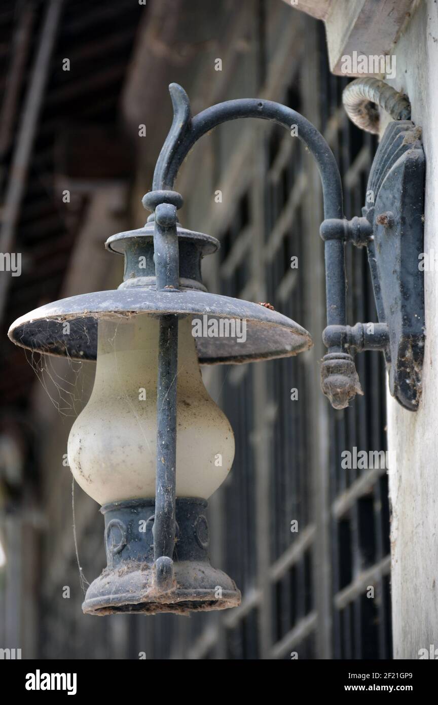 Alte Lampe außerhalb eines Gebäudes, staubig, schmutzig und vergessen. Stockfoto