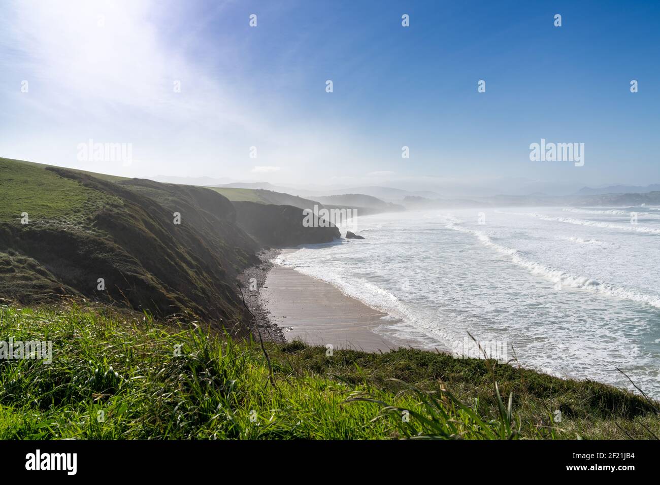 Hohe grüne grasbewachsene Klippen fallen hinunter zur Ozeanküste In Nordspanien Stockfoto