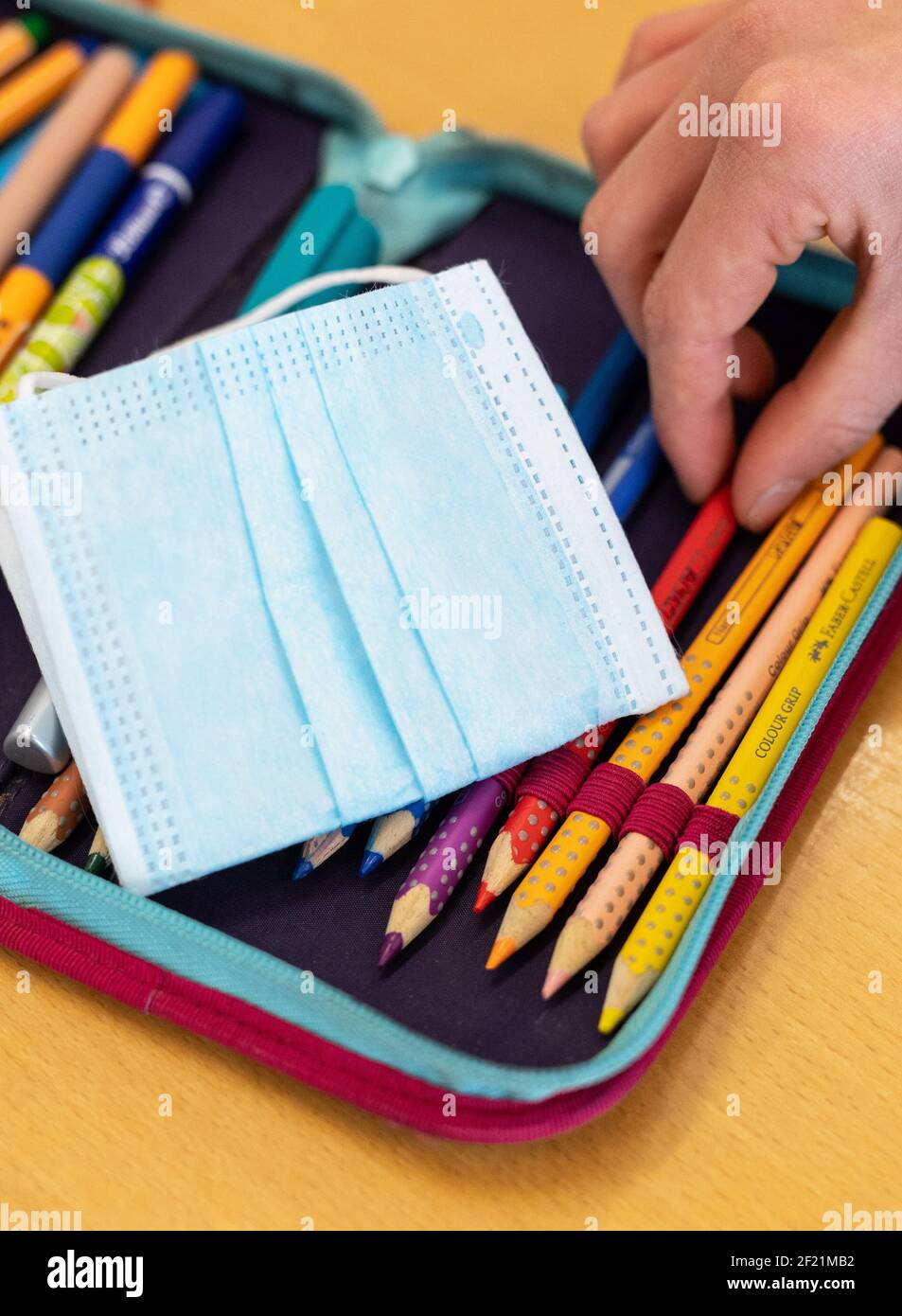 München, Deutschland. März 2021, 10th. Der Ersatz-Mundschutz eines Schülers liegt auf dem Bleistiftkasten des Schülers während des Unterrichts in einer vierten Klasse an einer Grundschule. Der bayerische Bildungsminister Piazolo (Freie Wähler) und der bayerische Gesundheitsminister Holetschek (CSU) besuchten die Grundschule, um die Umsetzung der Corona-Teststrategie zu sehen. Quelle: Matthias Balk/dpa/Alamy Live News Stockfoto